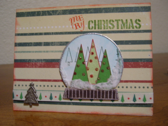 Snow Globe
This stamp is so fun to work with!  The globe is heat embossed with silver.  Large trees are stamped and cut out and decorated with stickles.  On the bottom of the globe is Flock. Blue in the globe is sponged on. There are also little snowflakes heat embossed on background, but they can't be seen in pic.  Globe is attached with dimensional dots.  The ribbon was too white for the paper so misted it with a water/perfect pearls solution.  The little trees is an old Making Memories from my stash.
