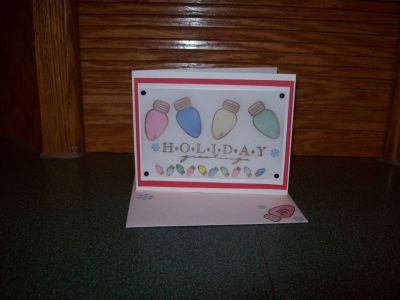 Holiday Greetings
This card was stamped with the Christmas Nov. Stamps. I used different layers of Red & white card stock. And Laser Vellum to stamp on. I used black brads on the corners. And for the small bulbs I used water color pencils and paint brush. I also stamped the matching envelope. That is just a little extra I like to do. 
