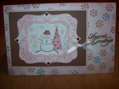 Snowman Season's Greetins
I used the Joy2Christmas Nov.09 Stamps to make the snowman and all the patterns on the card. I masked the trees behind the snowman. I made a 3D border using the cricut diecut system. I used pink ink to color the edges of the card. Also used Ribbon & Brads and pop dots to give dimension on layers. The Seasons greetings stamp is from My Sentiments Exactly. I used water color pencils and brush for some highlighting.
