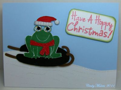 Have A Hoppy Christmas
Stamps:  froggy2love and penguins4christmas.  Paper:  Whisper White, Bashful Blue, Always Artichoke, Real Red.  Ink:  Garden Green, Pear Pizzazz, Real Red, Versamark.  Accessories:  Big Shot, Sizzix Die Flower, Wedding Foliage, Clear EP, Heat Tool, White Fun Flock, Gelly Roll Clear Star Pen 
Keywords: Christmas
