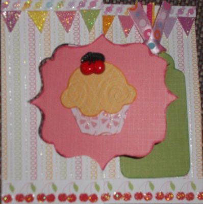 Decorative Flip It Cupcake 
I used the decorative flip it die. I cut out an extra middle section of pink textured paper. The cupcake is a Sizzix Cupcake & Ice Cream die, the icing was run through a swirly embossing folder. I put a cherry button on the top. I cut out a strip of paper with little candies for the top edge and then popped it up. I cut out the sparkly banner paper too and popped up those as well. The bottom edge is a strip of cherries on paper.
Keywords: Decorative Flip It die