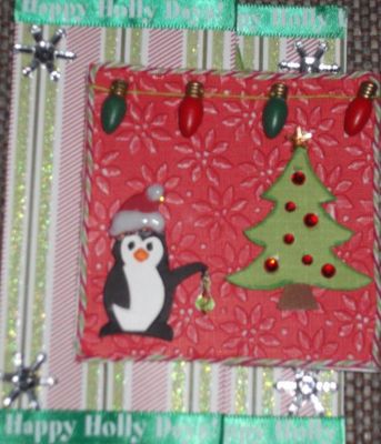 Penquin Christmas card
I used the square flip it die. I cut out an extra square section of red and ran it through a poinsettia embossing folder. The tree and penguin are also from a Sizzix embossing folder, then cut out. I strung wooden Christmas lights on the square, put ribbon on the top and bottom of the card and added snowflake bling to the corners.
Keywords: square flip it die
