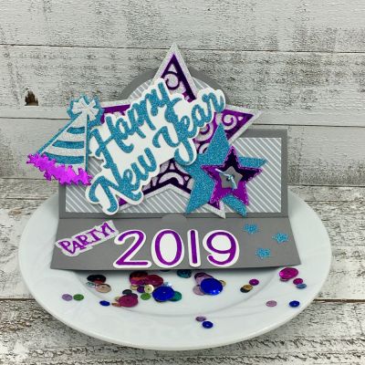 Happy New Year 
Happy NewYear 2018 Word Die, Sizzix Circle Stand-Ups Card Die Set, Sizzix Star Fold-its, Sizzix Triplits Party Hat, Stitched Star Dies, 3.5 inch Lowercase Dies, TSOL papers
