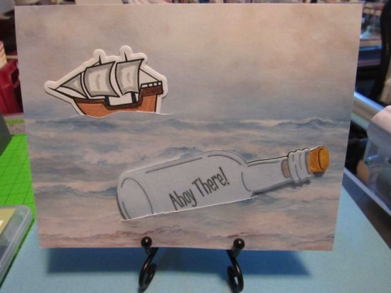Ahoy There!
I found a piece of pale blue vellum to cover the bottle to make it appear more like glass.  
