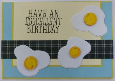 Have an Eggcellent birthday
Three die cut fried eggs are place on this Eggcellent birthday card. A couple of background papers and a checkered strip running left to right make this simple card design for the eggs to be on. Of course the stamped sentiment is cleverly put and goes perfectly together with the images. That's why I thought having only one set of these stamps wasn't enough and I am glad that I have both.
Keywords: eggs