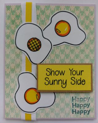 Show your sunny side (Front of card view)
These three fried eggs were stamped with black ink and then colored in with yellow and orange watercolors. I hand cut them but should have used the cutting dies for smoother edges. One of the yolks is stamped with a matching circular yolk stamp that matched my background paper perfectly. It also makes sense to see one of them a little different from the others...truly showing it's sunny side!
Keywords: eggs