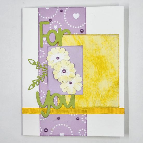 A simple card using TSOL products such as ribbon, patterned paper, purple embellishments and flower and leaf dies.
