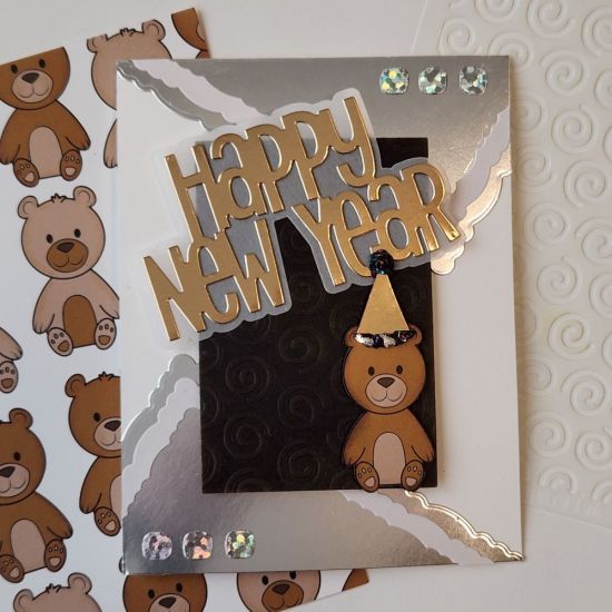 Happy New Year
Embossed with the Snail Fold-It Swirl Stencil. Cut out the bear from the paper pad. Happy New Year die set was a free gift in one of the Card Kits I received. Deckle Edge rectangle shapes used to cut the silver paper. 
Keywords: Deckle Edge Shapes, stencil from Snail Fold-It Club, Remember When Paper Pad from November 2022 Card Kit